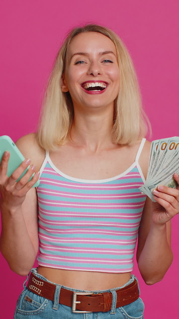 Gelukkige vrouw gebruikt smartphone verheugd spel winnen ontvangen geld dollar contant vieren succes