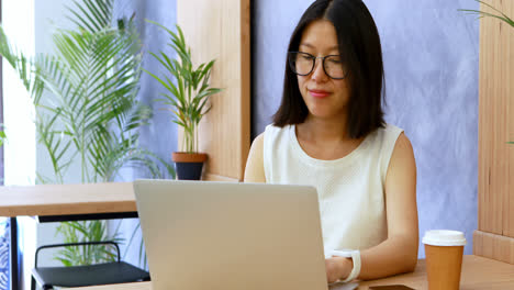 Ejecutiva-Femenina-Comprobando-El-Tiempo-En-El-Reloj-Inteligente-Mientras-Trabaja-En-El-Escritorio-4k