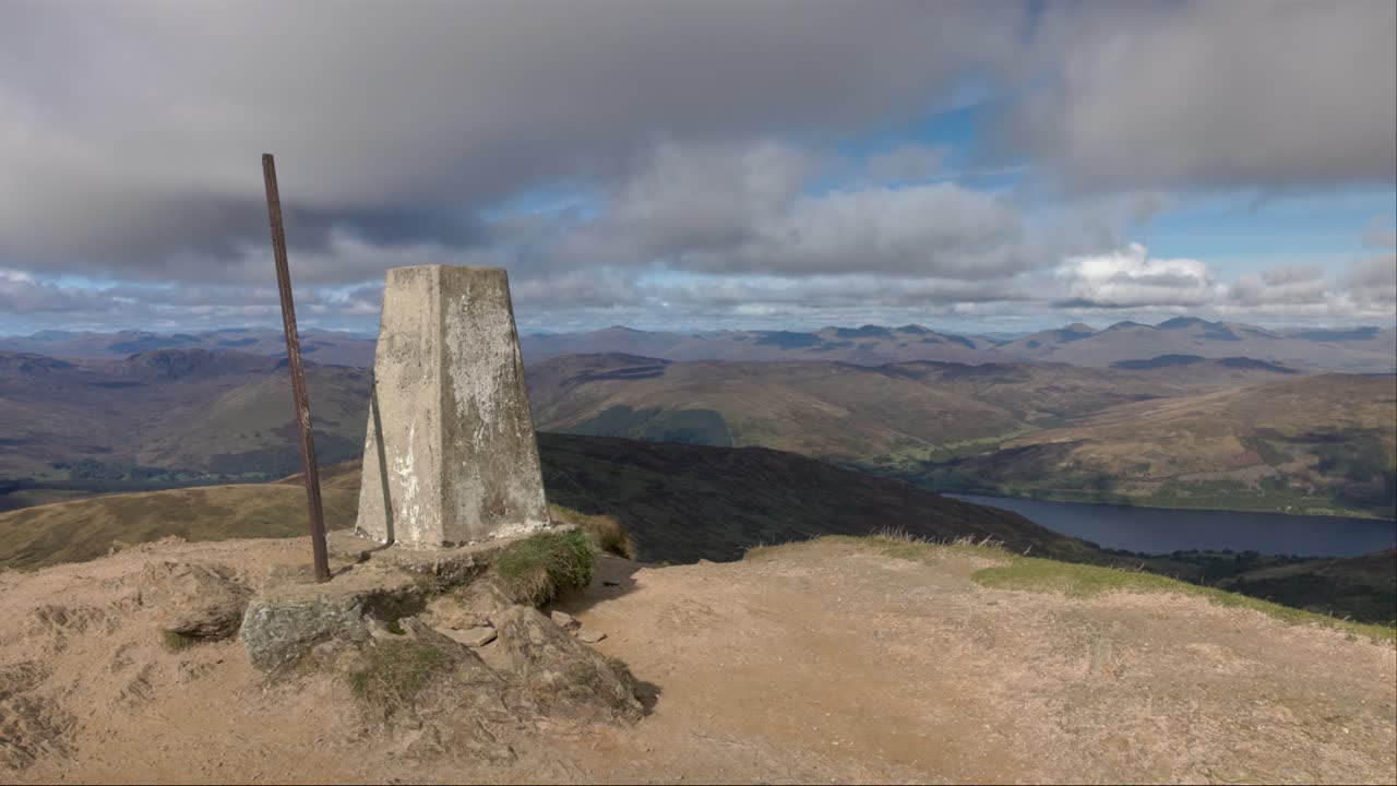 close-up shot of the trig point on the summit of Ben Vortlich in summer