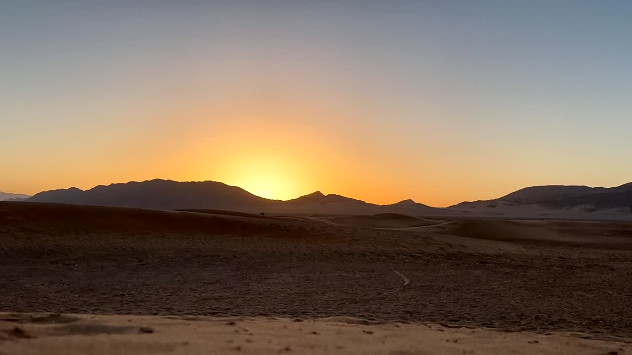 hermoso amanecer en el desierto del sahara con dunas de arena y montañas