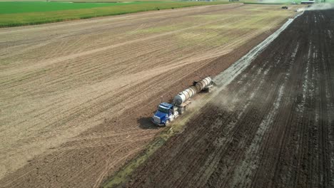 un camión cisterna extiende estiércol líquido en un campo de una granja de wisconsin recientemente cosechado de ensilado de maíz
