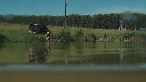 fisherman sits on the shore of the lake 2