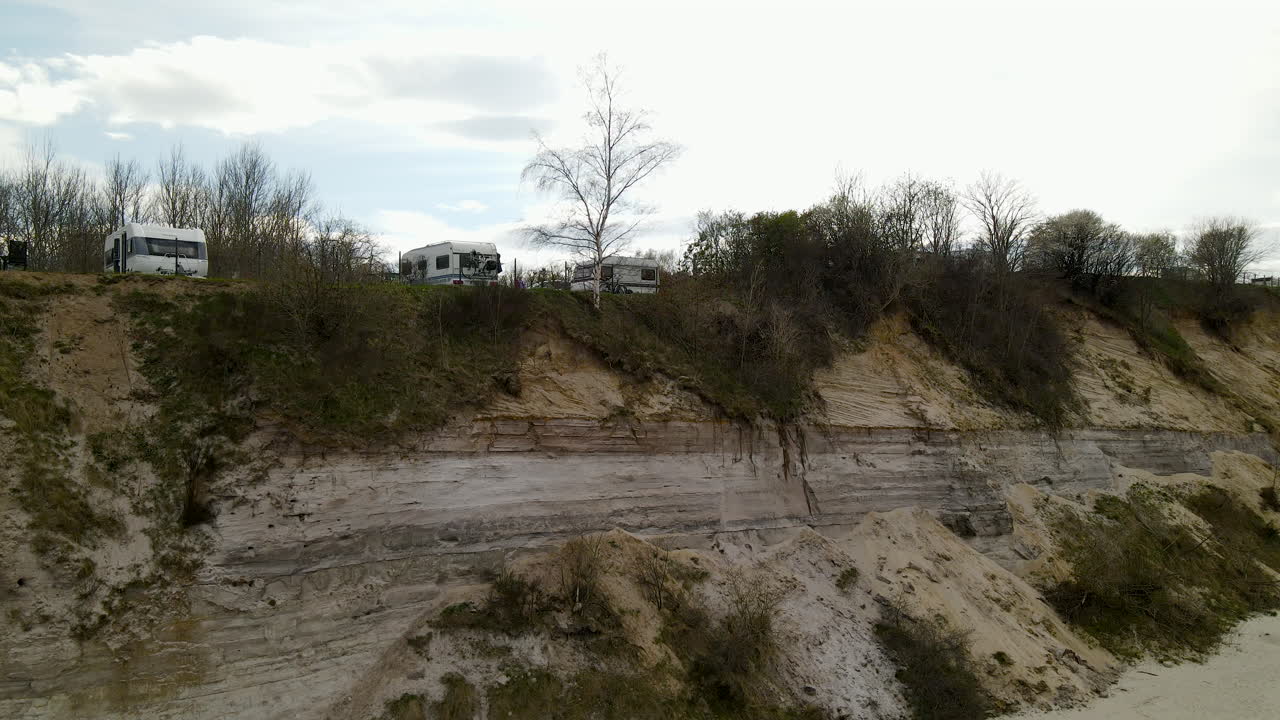 drones aéreos despegan sobre el área de estacionamiento del remolque camper cerca de la costa rocosa del mar báltico