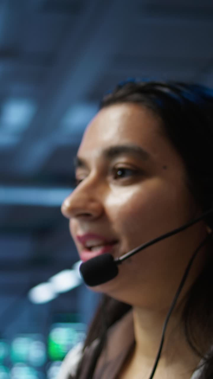 Ung kvinne snakker i headset-mikrofon i kundesenter