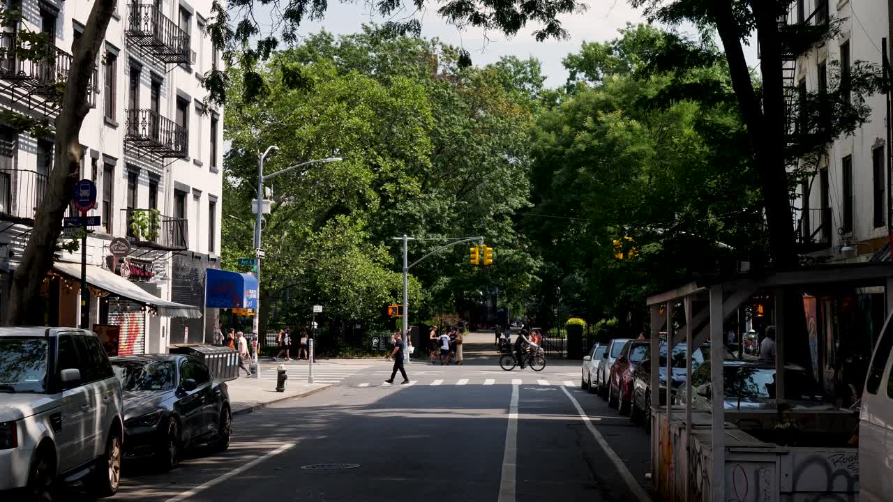 Slow motion landscape of pedestrian crossing on neighbourhood street road intersection with traffic lights and apartment blocks Tompkins Park New York City USA America travel tourism