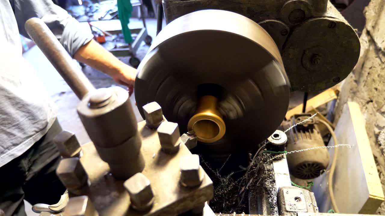 cerca o máquina de fresado en acción. girador irreconocible trabajando con un viejo banco de trabajo en su garaje o taller. mecánico usando torno para el procesamiento de metales. movimiento lento