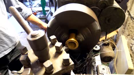 cerca o máquina de fresado en acción. girador irreconocible trabajando con un viejo banco de trabajo en su garaje o taller. mecánico usando torno para el procesamiento de metales. movimiento lento