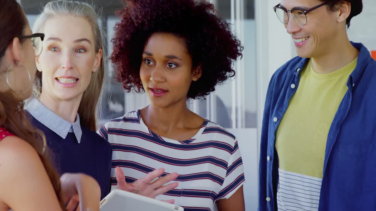 compañeros felices interactuando entre sí mientras usan una tableta digital 4k