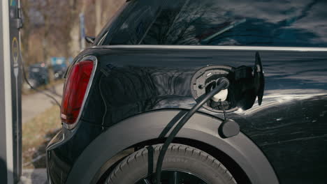 black electric car charging at a station