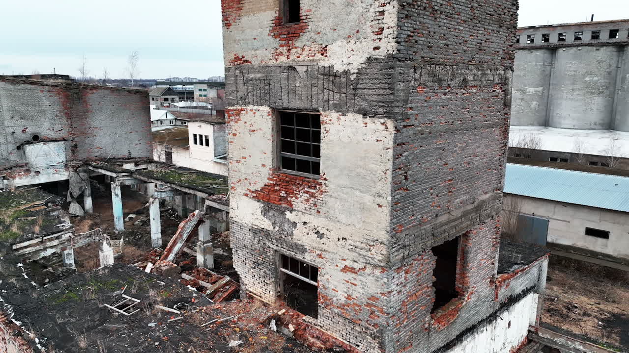 Bare brick walls and window holes in the bombed buildings. Ruined architecture resulting from air strike. Drone shot.