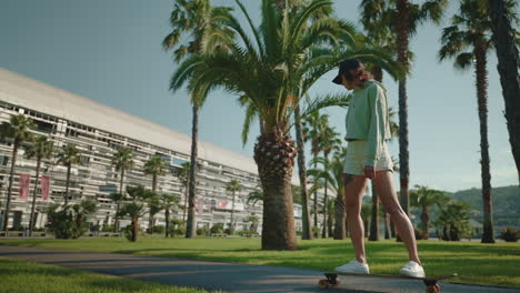 woman skateboarding in park near building