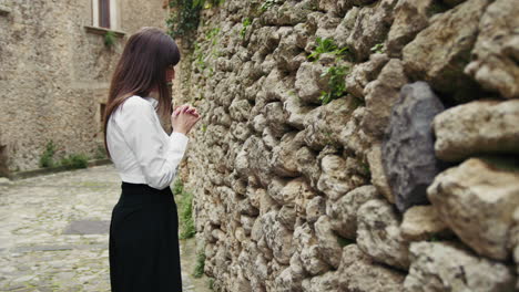 woman praying with focus in front of the sacred wall