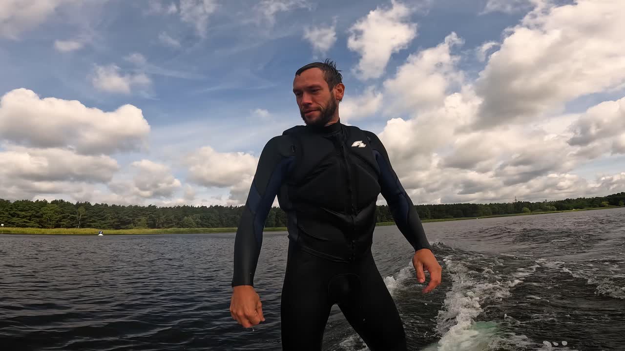 surfer na longboardzie surfuje na falach i robi przełącznik z chmurami na niebie nakręcony z gopro 60fps