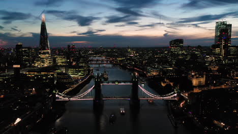 Aerial-View-of-London-over-the-River-Thames-including-Tower-Bridge,-Shard-and-the-Tower-of-London-at-twilight