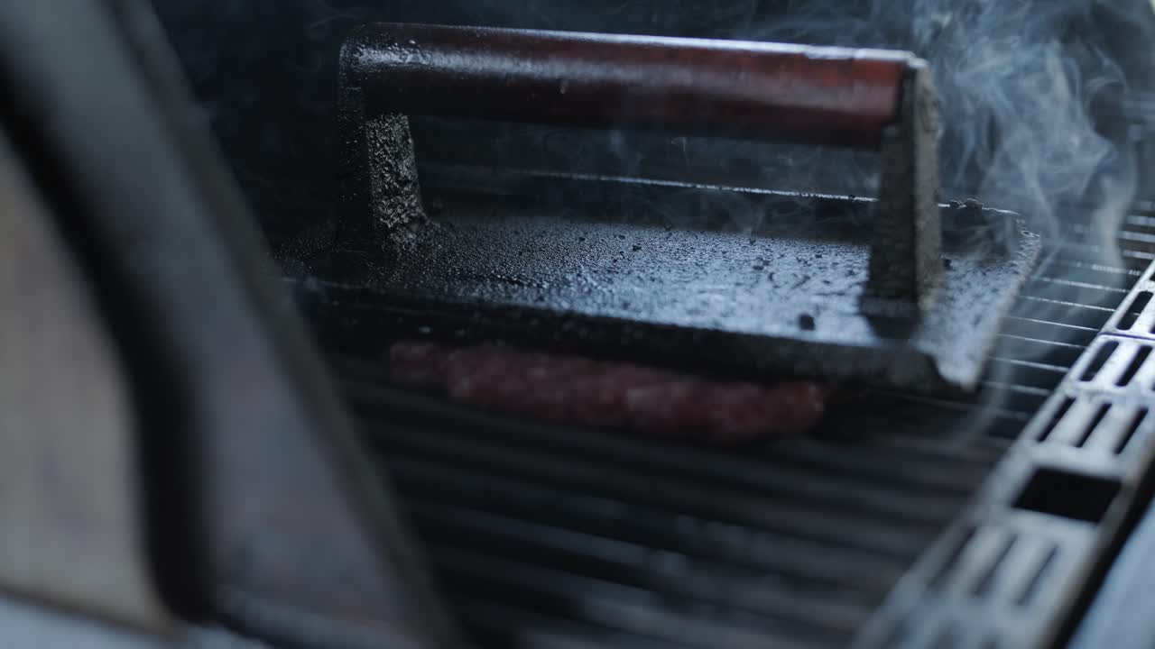 chef asando hamburguesas en la parrilla al aire libre