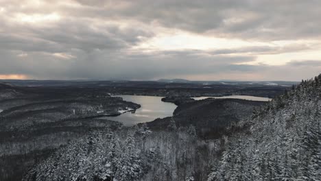 Lago-Stukely-Rodeado-Por-Un-Bosque-De-Pinos-Nevados-En-Un-Atardecer-De-Invierno-Nublado-En-El-Parque-Nacional-Du-Mont-orford-En-Quebec,-Canadá