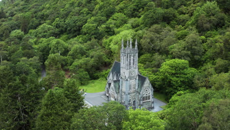 lugar turístico popular europeo - edificio del castillo de la abadía de kylemore en irlanda, estableciendo una vista aérea de drones