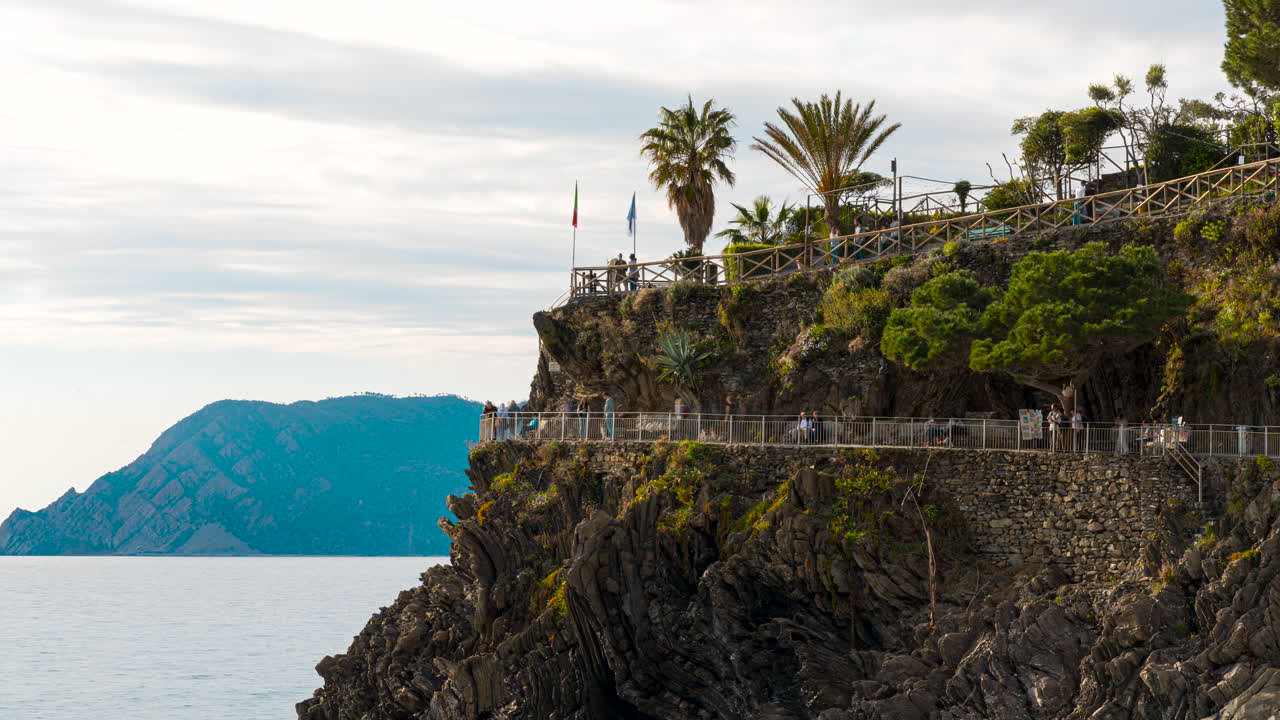 lapso de tiempo de los turistas caminando por el sendero del acantilado de manarola, italia y disfrutando de la vista