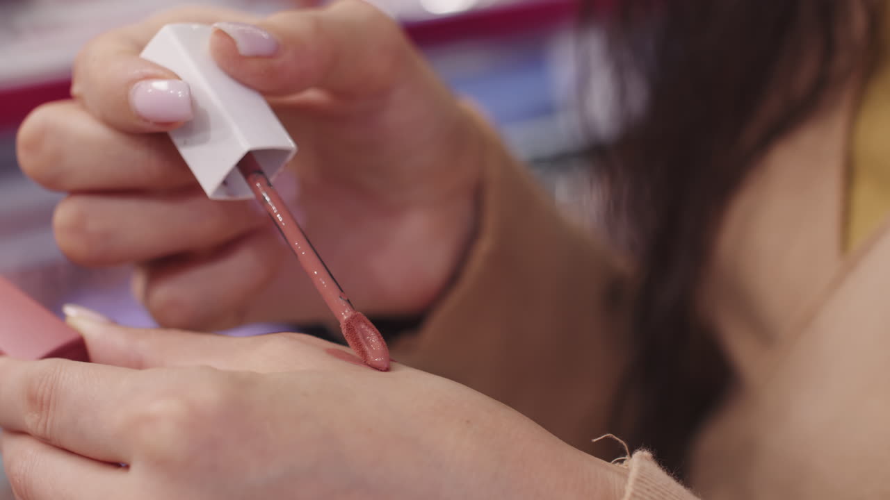 Female Customer Testing Lipstick In Make-Up Shop