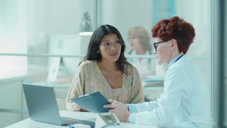 Female-Doctor-Explaining-Diagnosis-to-Hispanic-Woman-in-Clinic