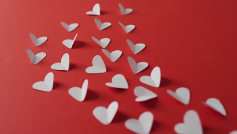 corazones de papel rosa sobre fondo rojo en el día de san valentín