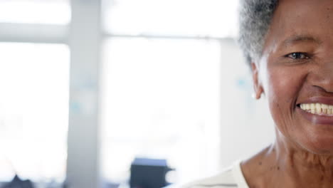 Half-portrait-of-happy-african-american-senior-woman-in-hospital-with-copy-space,-slow-motion