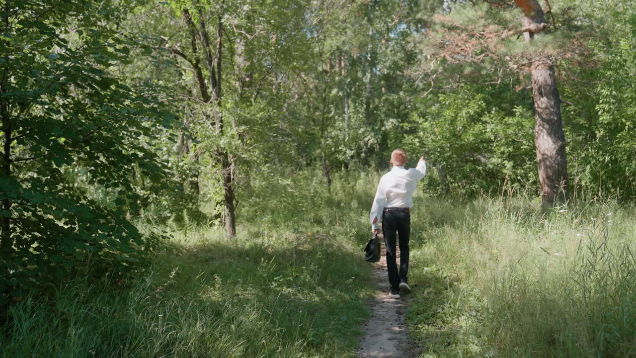 Man Walking Through Forest with Briefcase