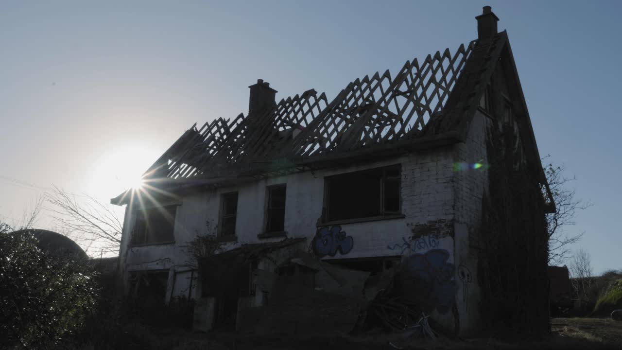 Sun Appears From Behind The Old Abandoned Derelict House In Northern Ireland - Low Angle Shot