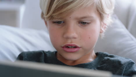 Fröhlicher-Kleiner-Junge,-Der-Einen-Digitalen-Tablet-Computer-Benutzt-Und-Ein-Spiel-Spielt,-Das-Sich-Zu-Hause-Auf-Dem-Sofa-Entspannt.-Kind-Surft-Online-Mit-Mobiler-Gerätetechnologie,-Antisoziales-Suchtkonzept-4k