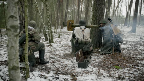 german soldiers with anti-aircraft gun in winter forest