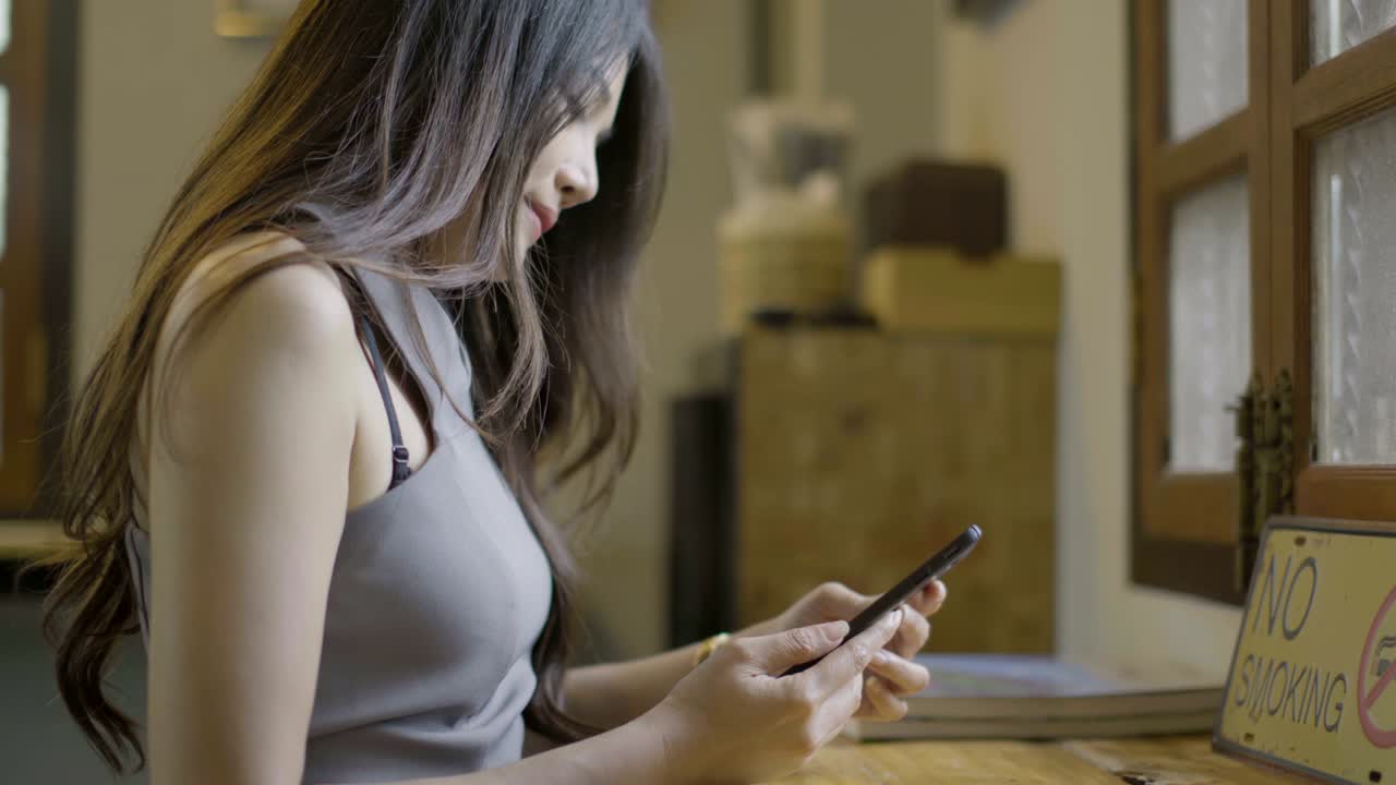 아시아 여성들이 커피에서 드폰을 치고 있습니다.