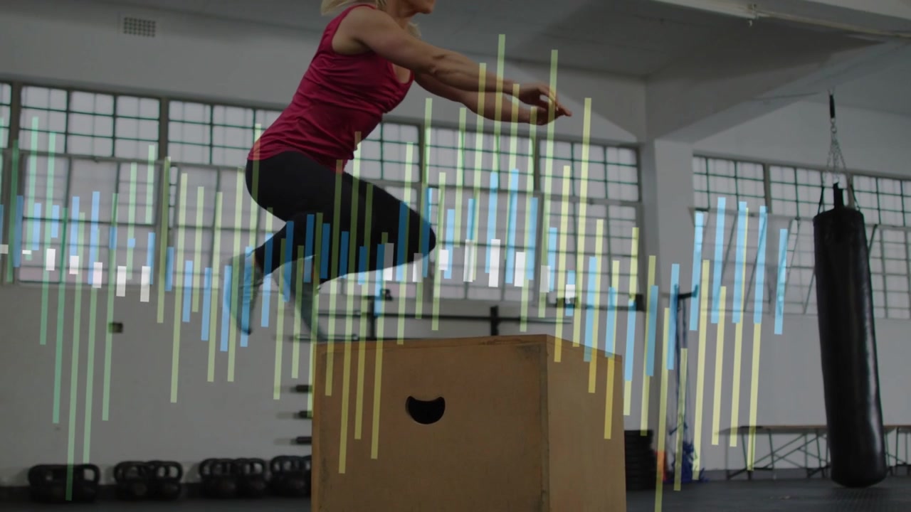 Woman doing plyo box jumps in gym, swinging arms back, landing for power, overlay appearing