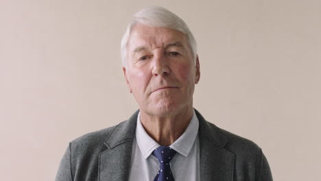 portrait of serious elderly businessman standing wearing suit