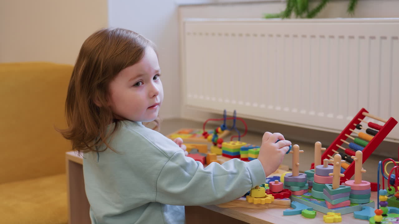 Camera capturing swing and ladder toys on table, colorful pieces arranged neatly, playful miniature set, close view with shallow focus, indoor light, simple background, clear detail for education