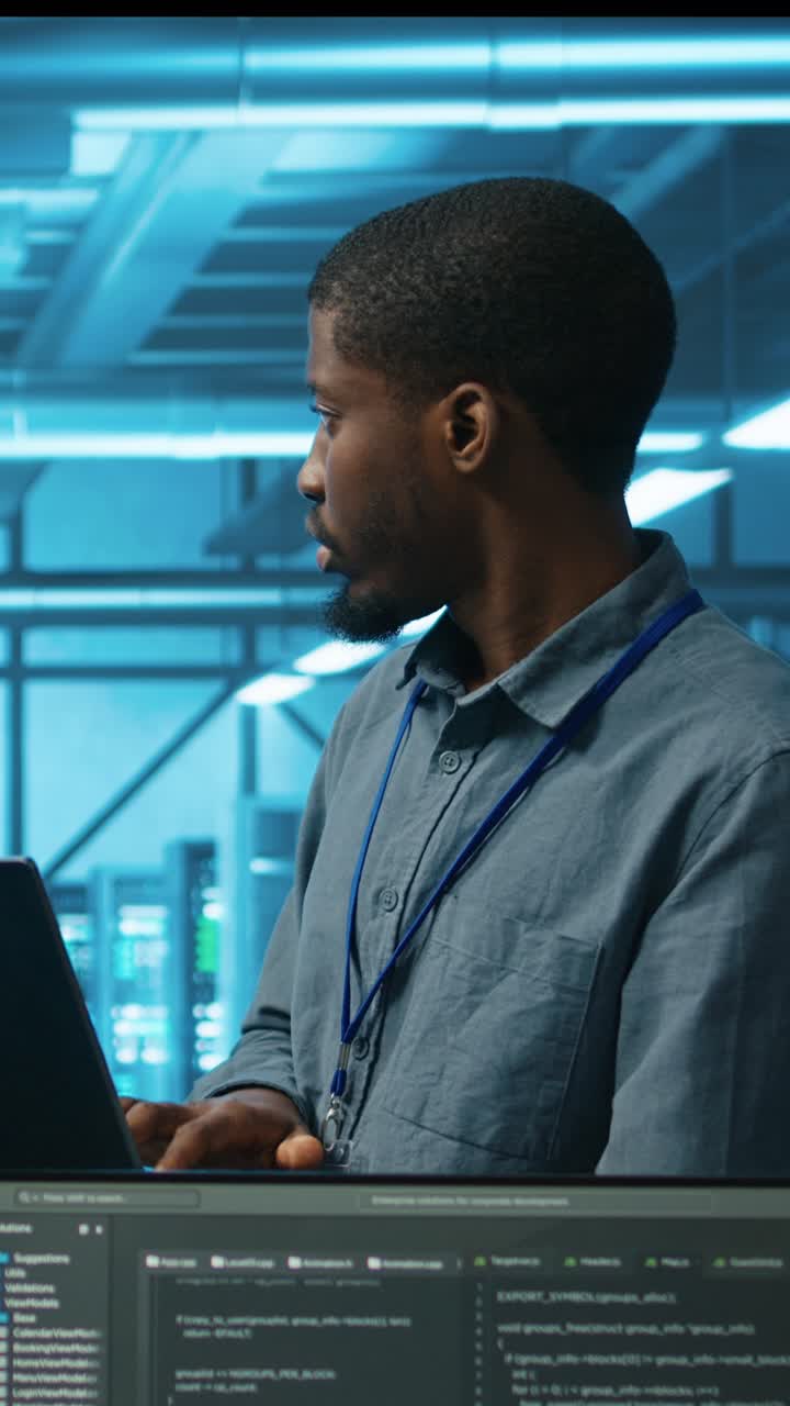 African American Programmer Working on Laptop in Data Center