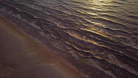 beautiful aerial establishing birdseye view of baltic sea coast on a sunny evening, sunset, golden hour, beach with white sand, sun reflection, coastal erosion, climate changes, wide angle drone shot