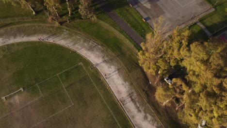 vista aérea de arriba hacia abajo de los atletas que corren en la pista durante las sesiones de entrenamiento
