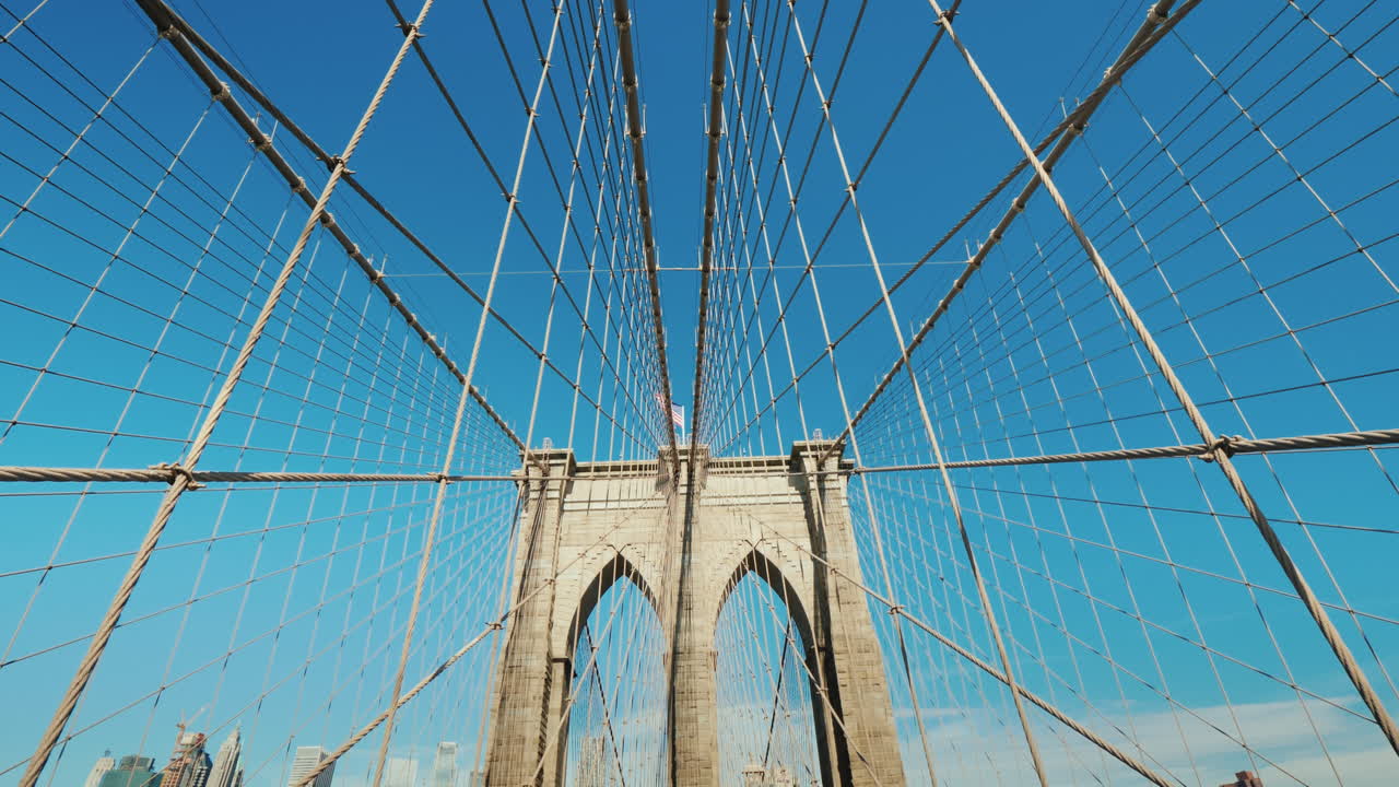 고요한 푸른 하늘을 배경으로 다리의 브루클린 다리 철탑과 밧줄을 걷다