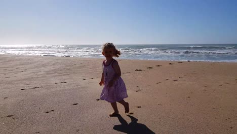 Kleinkindmädchen-Im-Gestreiften-Kleid,-Das-Am-Strand-Spielt