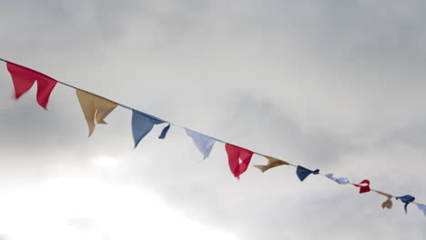 colorful flags on rope hanging outside in cloudy day