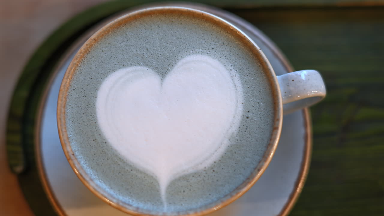 Top down shot of foam latte art on blue matcha drink