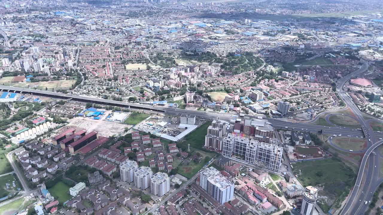 A beautiful aerial drone footage of the city of Nairobi, Kenya, showcasing the bustling urban office spaces, modern residential areas, the Nairobi Expressway, and Waiyaki Way. Captured during the day