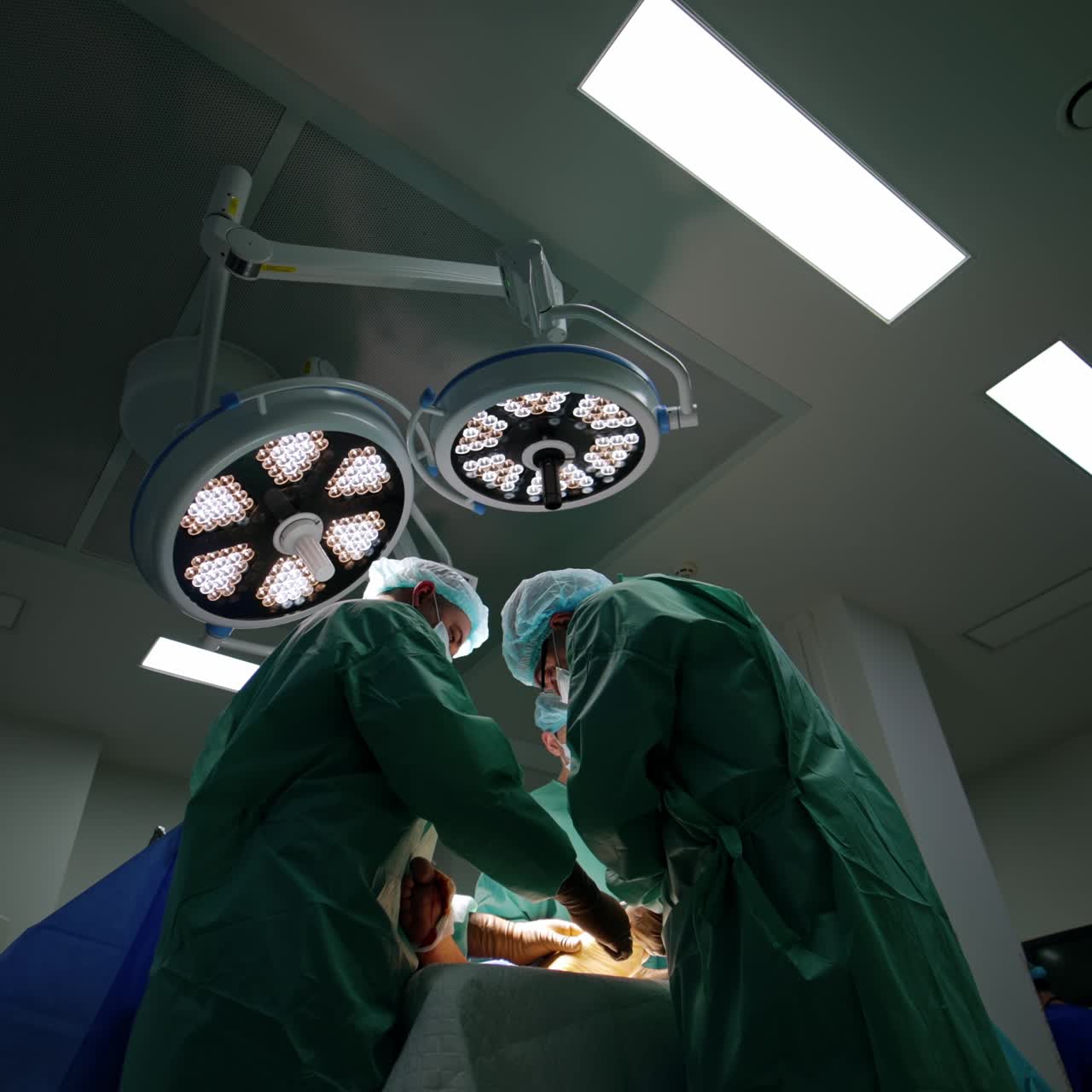 Un gruppo di chirurghi in piedi vicino al tavolo operatorio. Angolazione dal basso. Professionisti eseguono un intervento chirurgico su un trauma