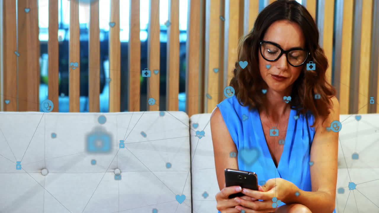 animación de una red de conexiones con iconos digitales sobre una mujer de negocios caucásica que utiliza un teléfono inteligente