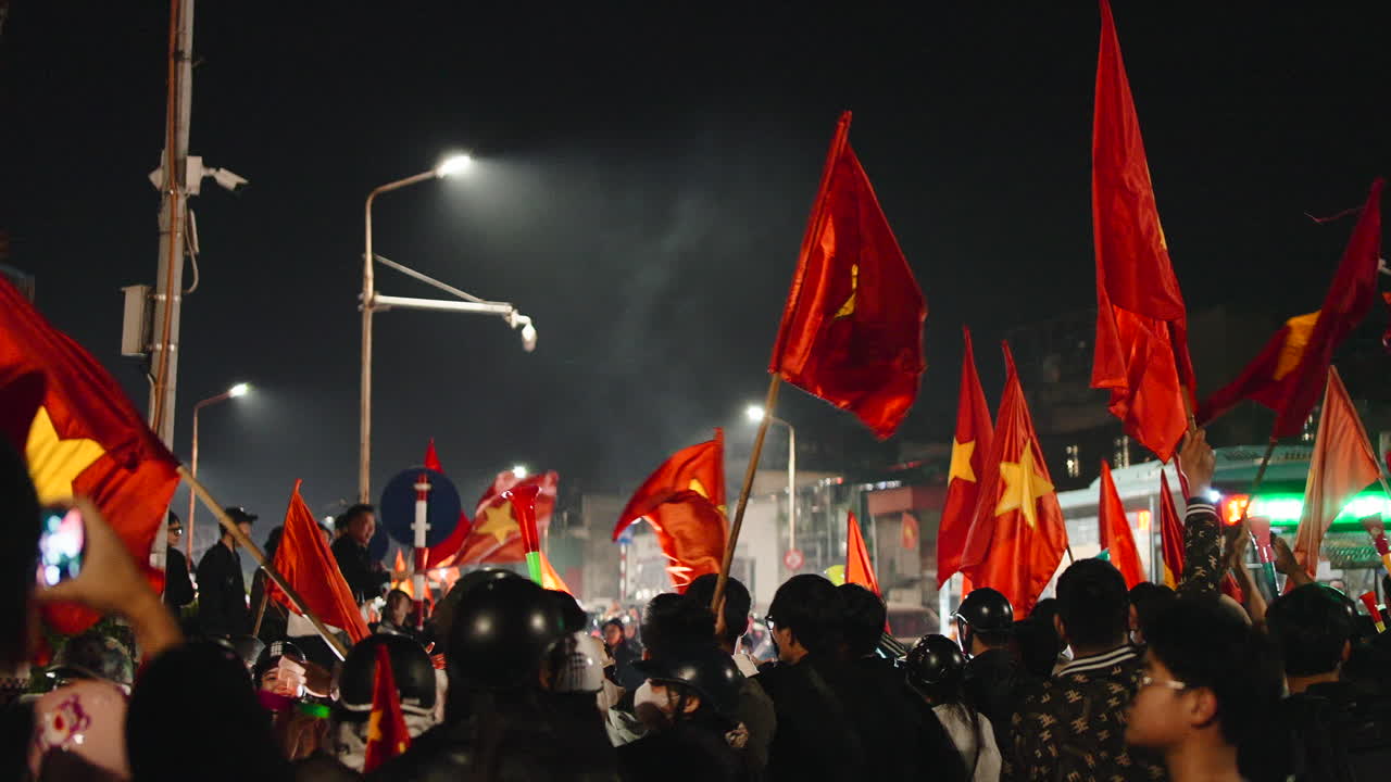 Crowd waving Vietnamese flags at night