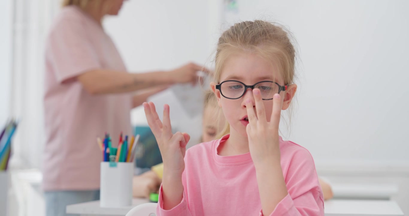 Bambina concentrata che impara la matematica contando sulle dita