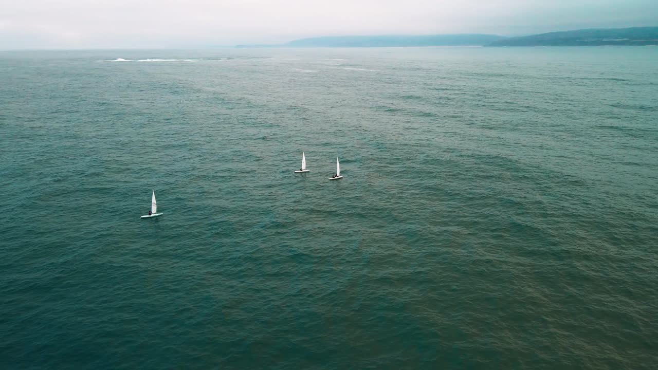 Drone aerial orbit of sailboats on the Pacific off Valparaiso, Chile, on an overcast day