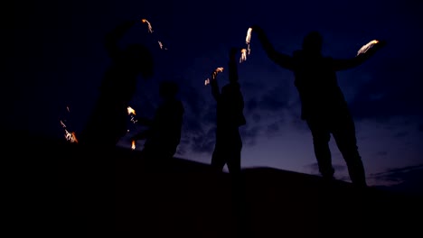 un grupo de amigos emocionados teniendo una fiesta nocturna con chispas
