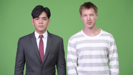 젊은 잘생긴 아시아 사업가와 젊은 스칸디나비아 사업가가 함께 일하고 있습니다.