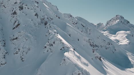 una hermosa vista de los picos de las montañas cubiertos de nieve en el soleado día de invierno